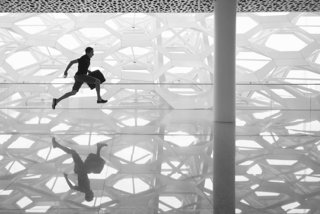 Personne bondissant dans le hall vitré d'un immeuble contemporain