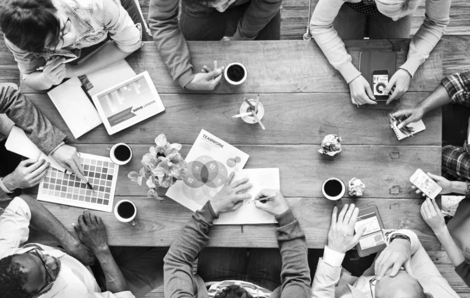 Vue de dessus d'une réunion autour d'une table, tasses de café et documents