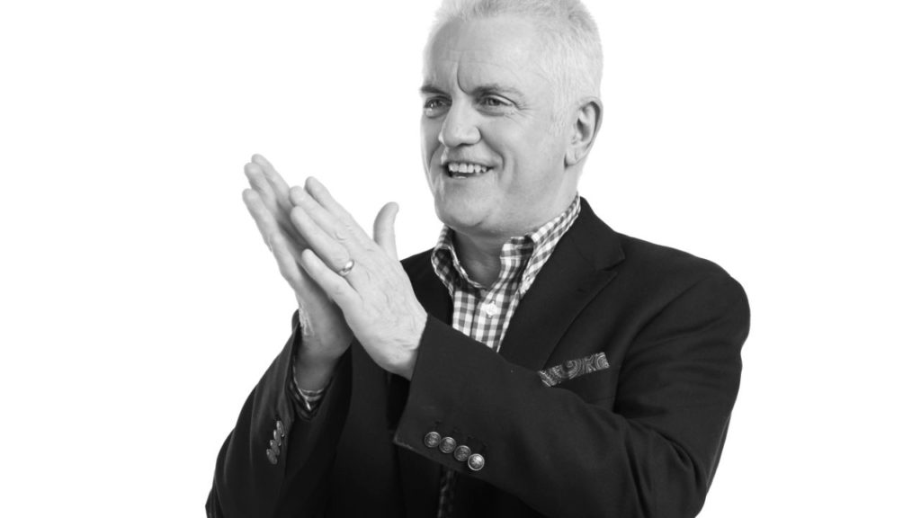Homme souriant qui applaudit, sur fond blanc