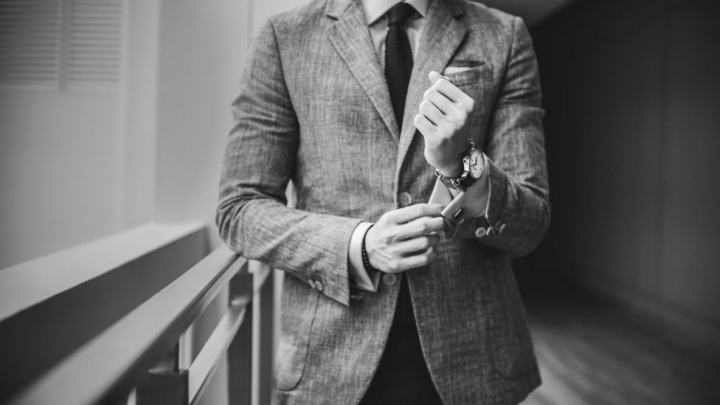 Homme en veste ajustant son costume avant un rendez-vous