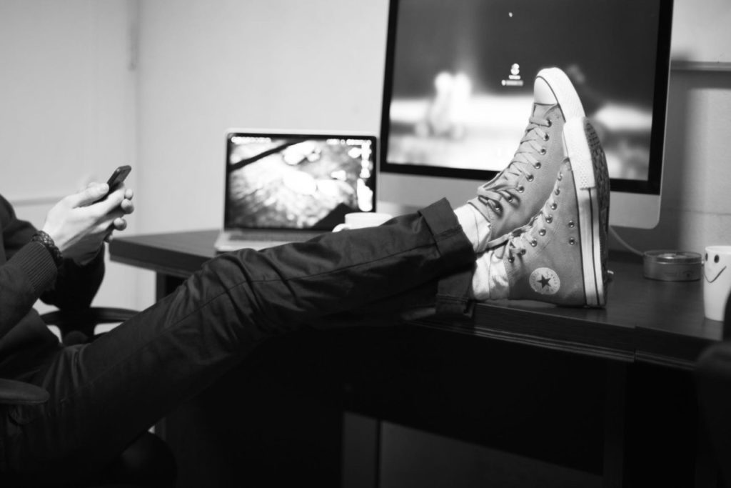 Personne les pieds posés sur le bureau devant son écran