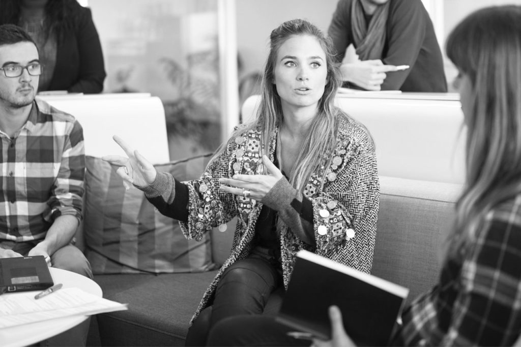 Groupe de jeunes professionnels en discussion sur des canapés